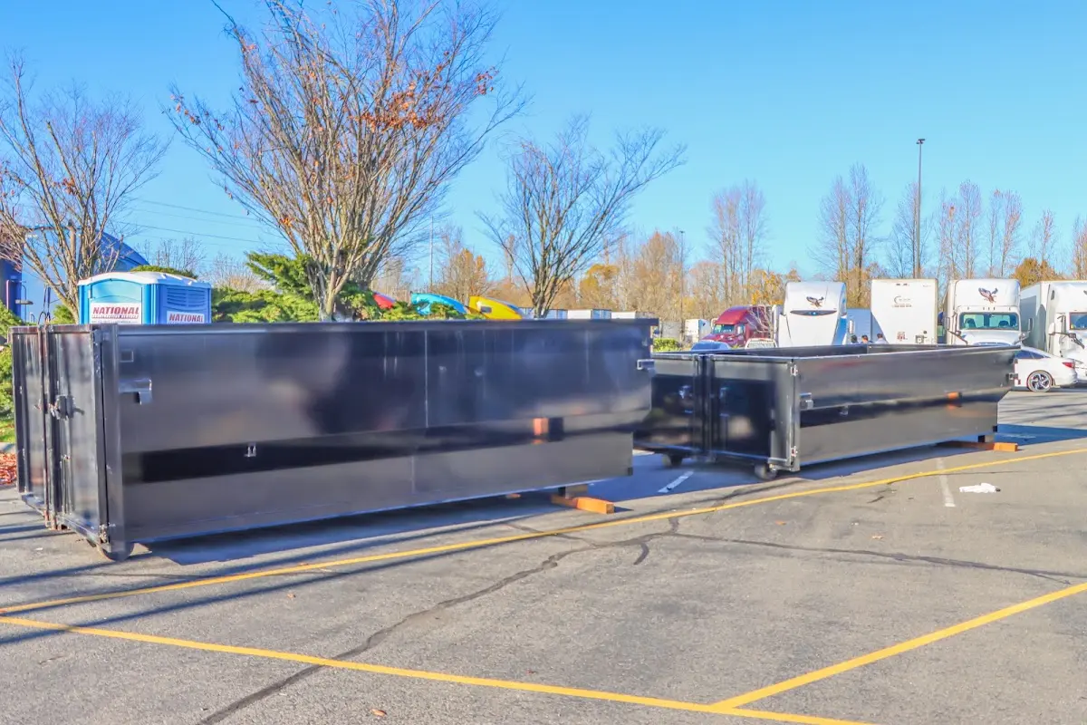 Professional dumpster rental service with roll-off container on residential driveway in Kula